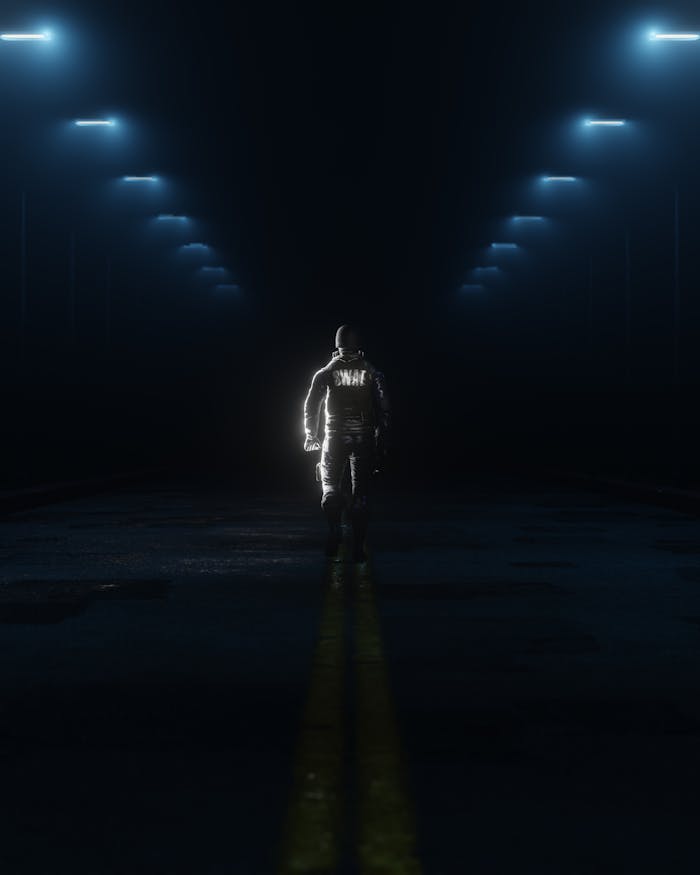 A SWAT officer walks alone on a dimly lit street at night, creating a dramatic mood.